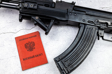 Kalashnikov assault rifle and military ID. Translation: 