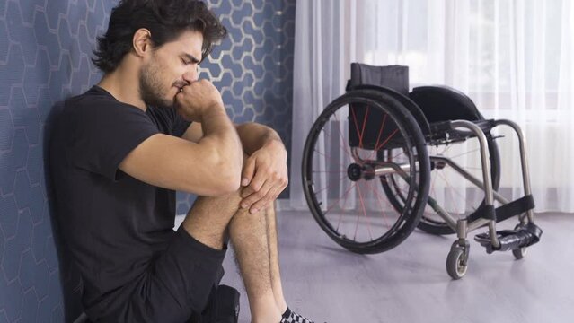 Sad and crying disabled teenager.
Disabled man alone leans against a wall and thinks.
