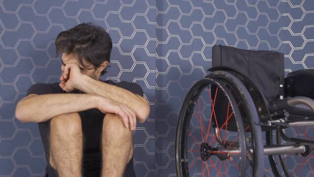 The disabled young man is unhappy and resentful of life.
Disabled man leans against a wall alone and is unhappy.
