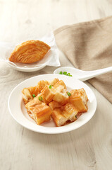 Close up view of bowl of traditional Chinese porridge and fritters on woooden table.