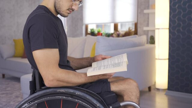 Disabled person reading a book in a wheelchair.
Disabled young man reading a book at home.
