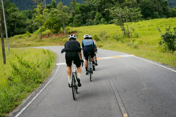 Obraz premium Groups of cyclists riding road bikes in the morning are climbing.