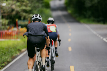 Groups of cyclists riding road bikes in the morning are climbing.