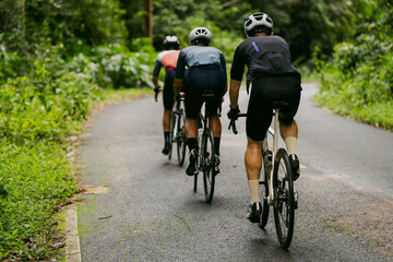 Fototapeta premium Groups of cyclists riding road bikes in the morning are climbing.