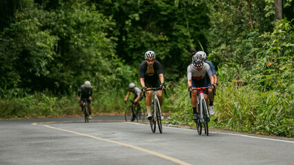 Obraz premium Groups of cyclists riding road bikes in the morning are climbing.