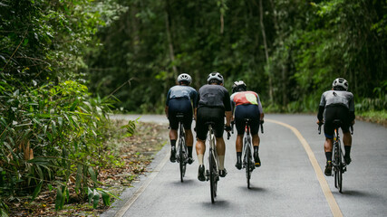 Groups of cyclists riding road bikes in the morning are climbing.