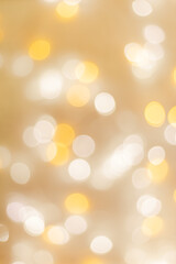 Abstract bokeh background beige colored, flare from lights, beige monochromatic vertical photo with optical effect, blurred round bokeh texture as holiday backdrop, celebration screensaver