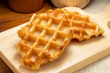 Waffles with butter and honey on a wooden tray ready to serve.