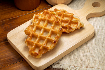 Waffles with butter and honey on a wooden tray ready to serve.