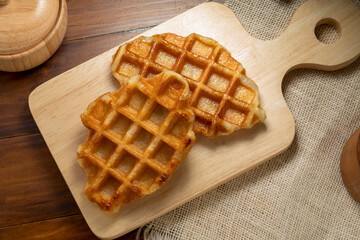 Waffles with butter and honey on a wooden tray ready to serve.