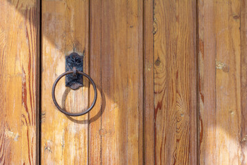 An old wooden door with a round iron handle.