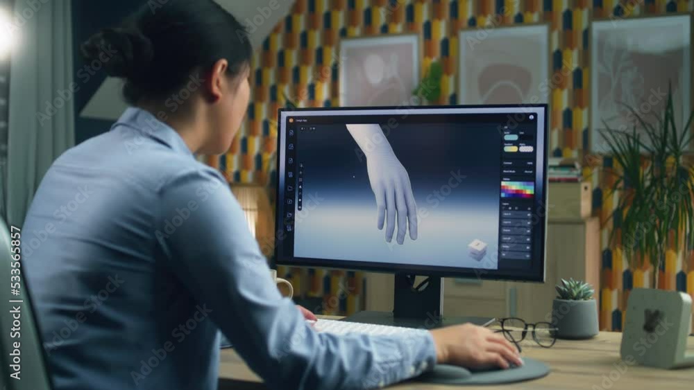 Poster woman sitting at the table at home office and making 3d prototype of human hand in professional prog