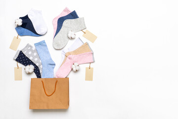 Various modern trendy women's cotton socks set with cotton flowers and price tags in shopping bag on white background. Fashionable socks store. Socks shopping, sale, merchandise, advertisement concept