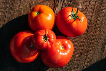 Organic food, harvest. Ripe red tomatoes lie on a wooden table. Top view flat lay