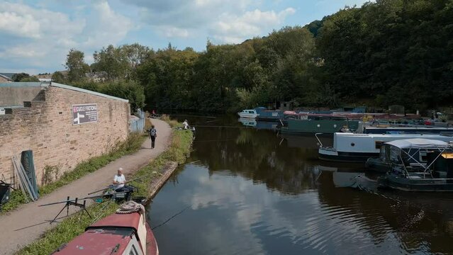 Aerial footage of a English canal with anglers, fishermen fishing For Roach and Bream. Angling competition in the UK. Showing the canal, barges, boats, and towpaths, walkway, footpath.
