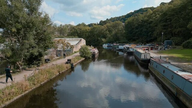 Aerial footage of a Canal with anglers fishing For Roach and Bream. Angling competition in the UK. Showing the canal, barges, boats, and towpaths, walkway, footpath.