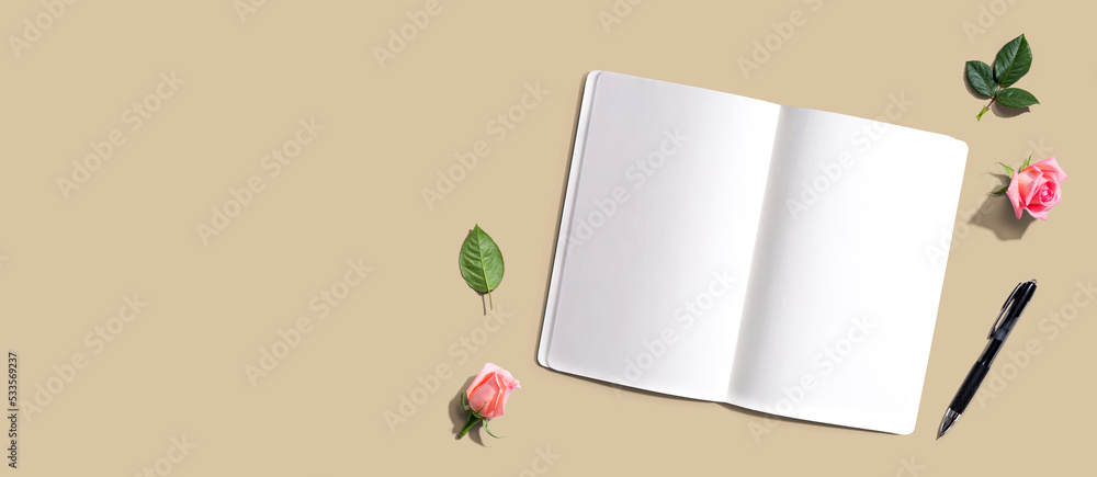 Poster open notebook or diary with a pen from above with rose buds- flat lay