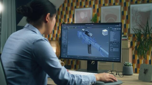 Female 3D designer creating 3D model of gun and making graphic using software for modeling 3D projects on pc while working at home