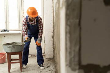 Man builder plasterer using trowel to plastering cement wall in home. building construction work...