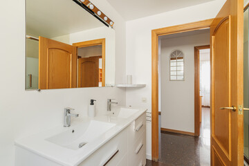 Fototapeta na wymiar Modern bright bathroom in a house with white tiles and rectangular large mirror