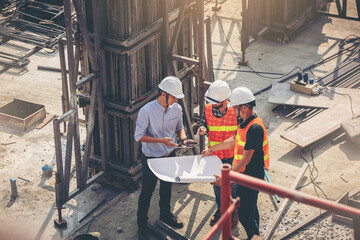 Structural engineer and foreman worker with blueprints discuss, plan working for the outdoors...