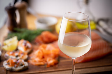 sliced salmon appetizer with glass of wine