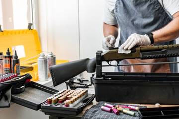 Close up of a man in apron wiping his firearm with a cloth