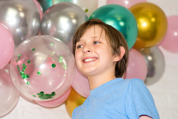 Fototapeta na wymiar portrait of a happy smiling boy on a holiday in front of the Balloons