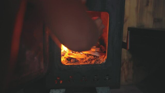 Close up of wood being placed into wood stove