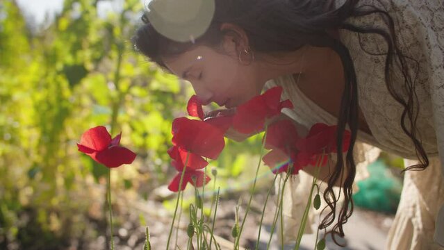 Female farmer smells flowers in garden