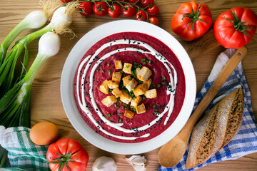 Beetroot and vegetable cream with bread croutons and cream. vegan soup.