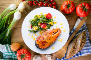 Grilled salmon with orange sauce and a salad. Typical Mediterranean coast dish.