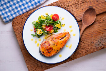 Grilled salmon with orange sauce and a salad. Typical Mediterranean coast dish.