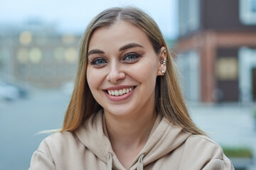 Close-up portrait of a young cheerful girl on the background of the evening city