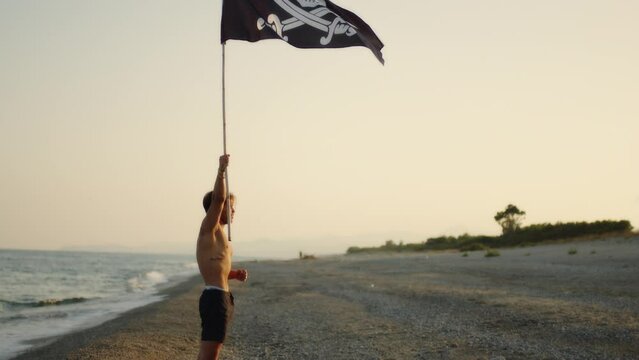 Boy waving pirate flag on a desert island