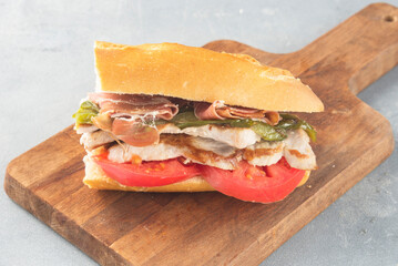 Sandwich Serranito typical in Andalusia with ham, green pepper and grilled pork loin