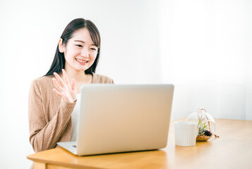 パソコンを使ってテレビ電話をする女性（動画配信）
