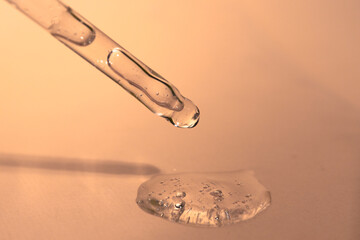 Hyaluronic acid in a glass pipette close-up. Liquid cosmetic texture for moisturizing and care.