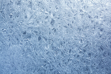 Fototapeta na wymiar The texture of the ice surface. Winter background, festive background in the form of ice crystals, in natural deep blue color.