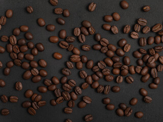 Freshly roasted Arabica coffee beans on a dark background.