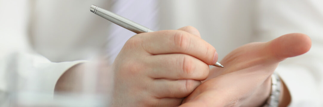 Male Writing Note With Silver Pen On His Hand To Keep In Mind Some Information