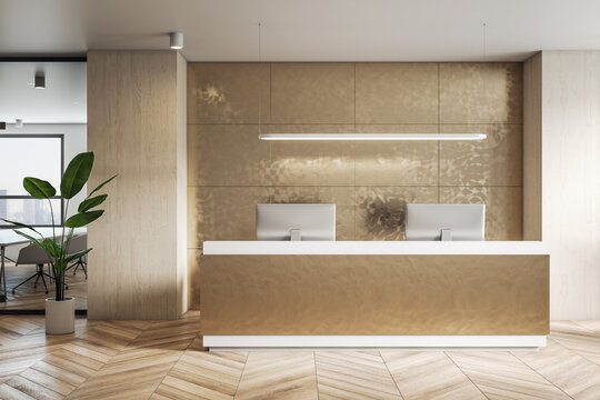 Front view on golden color reception desk in stylish office with modern computers, wall decoration and green plant on parquet floor. 3D rendering