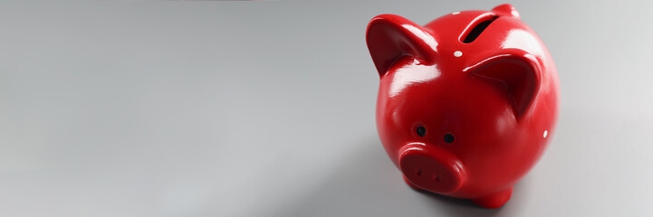 Bright red piggybank container on grey surface, empty thing to put money