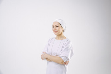 Portrait of a girl in a hijab in white clothes against a white background