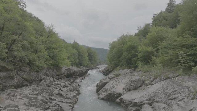 Aerial view of Mountain river and road. Flying over a mountain gorge. Slow motion 120 fps, ProRes 422, 10 bit ungraded DJI D-LOG video