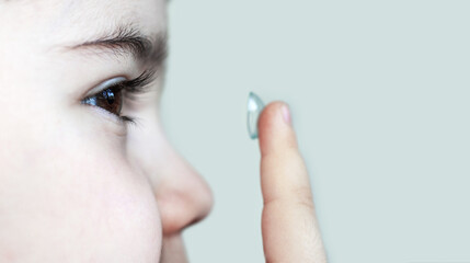 cute little boy putting contact lenses hold in finger.close up child eye isolated.myopia sight...