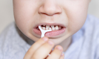 child uses plastic toothpick dental floss food remove daily care oral hygiene.flossing teeth every...