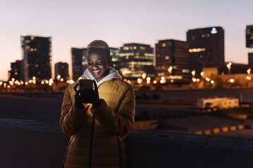 Modern African American man using smartphone app in the city at night