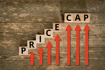 Price Cap on rising letters placed on wooden background with red arrows pointing upwards