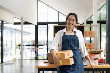 Startup small business entrepreneur SME freelance woman working with box, Young asian online market packing box delivery, SME delivery e-commerce telemarketing seller concept.